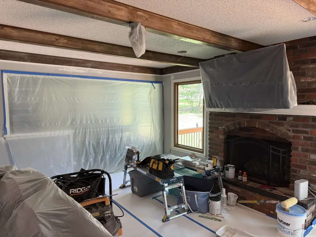 Dark ceiling beams with surrounding surfaces protected for painting