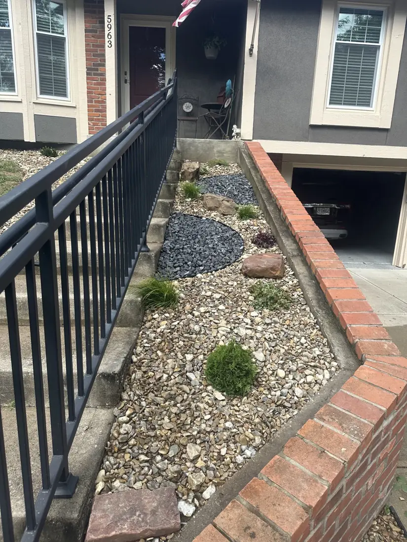 Refreshed planting bed with shrubs, grasses and contrasting decorative stone