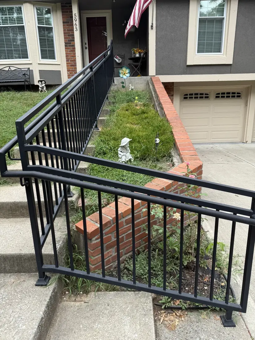 Overgrown planting bed beside the front steps before landscaping